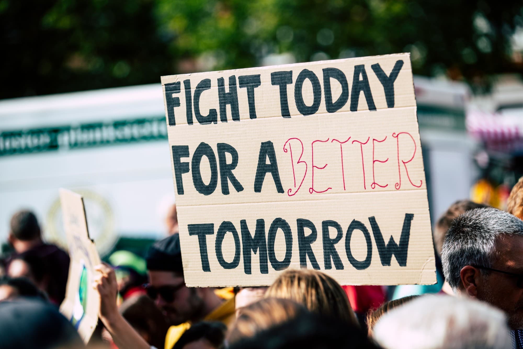 A cardboard protest sign reading: Fight today for a better tomorrow